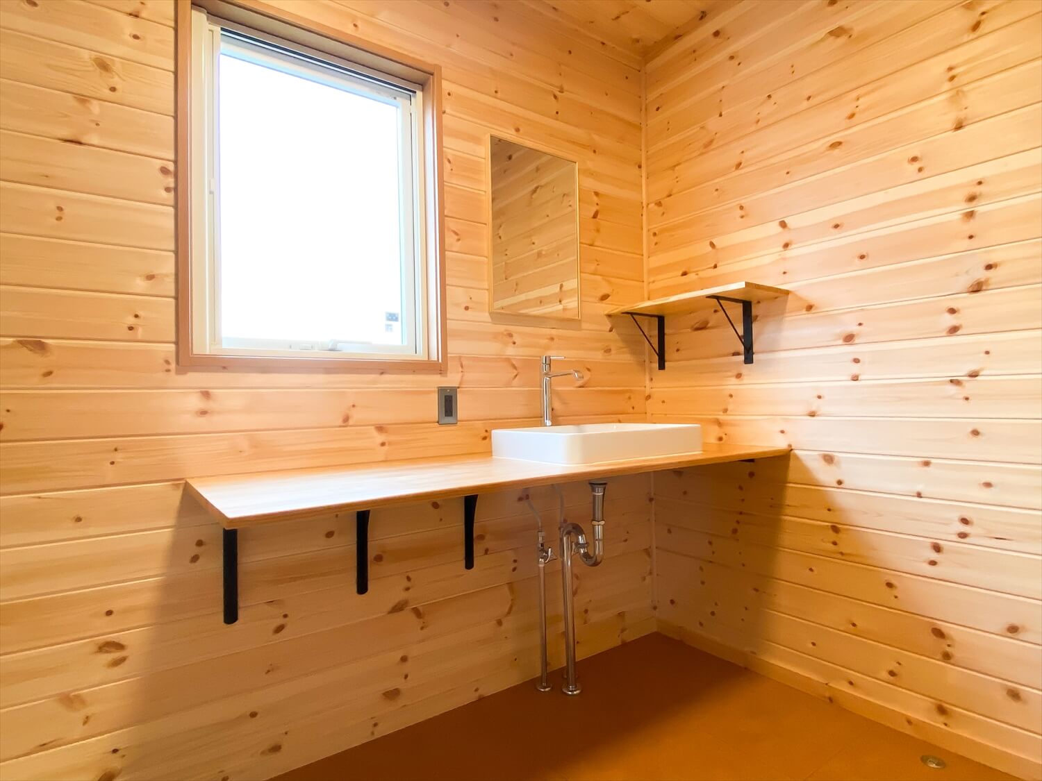 住宅街に建つログハウス風の平屋のおしゃれな洗面台｜つくば市の注文住宅,ログハウスのような木の家を低価格で建てるならエイ・ワン